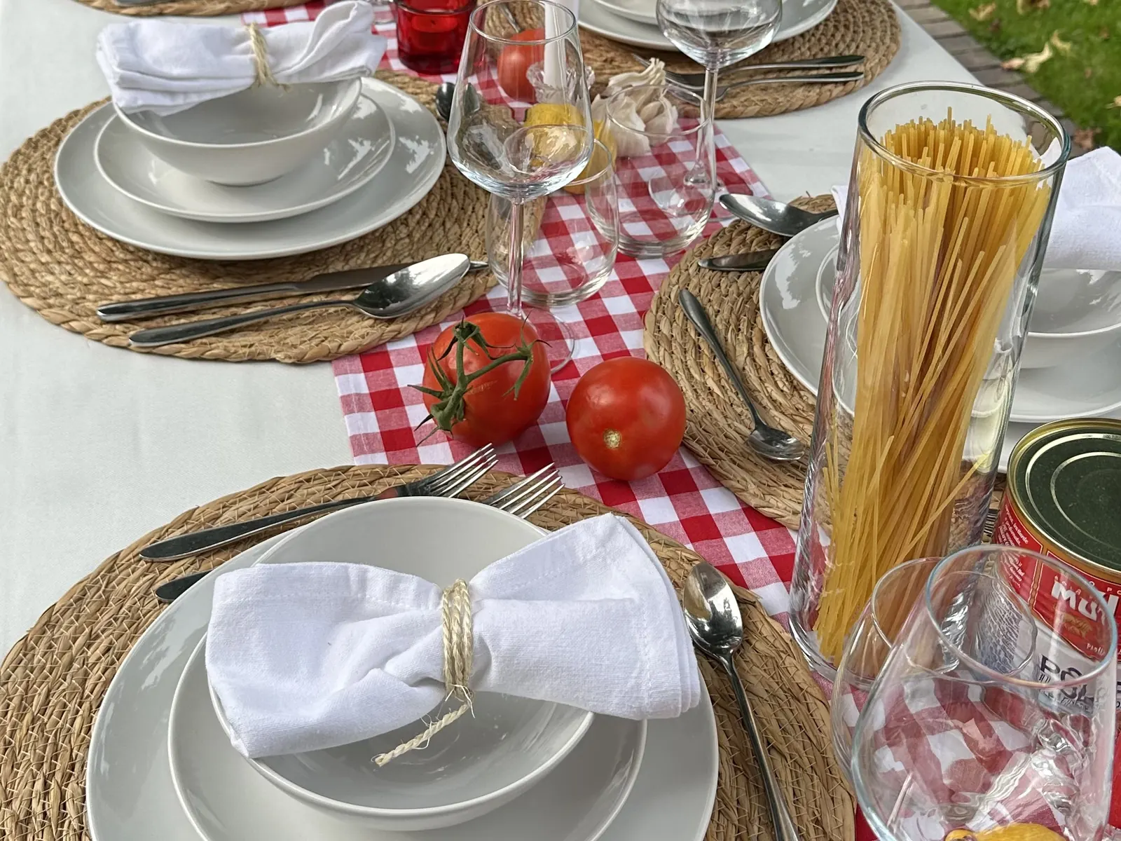 Italian Nights tafel met rood-wit geblokte loper, spaghetti, tomaten en servetten met touw
