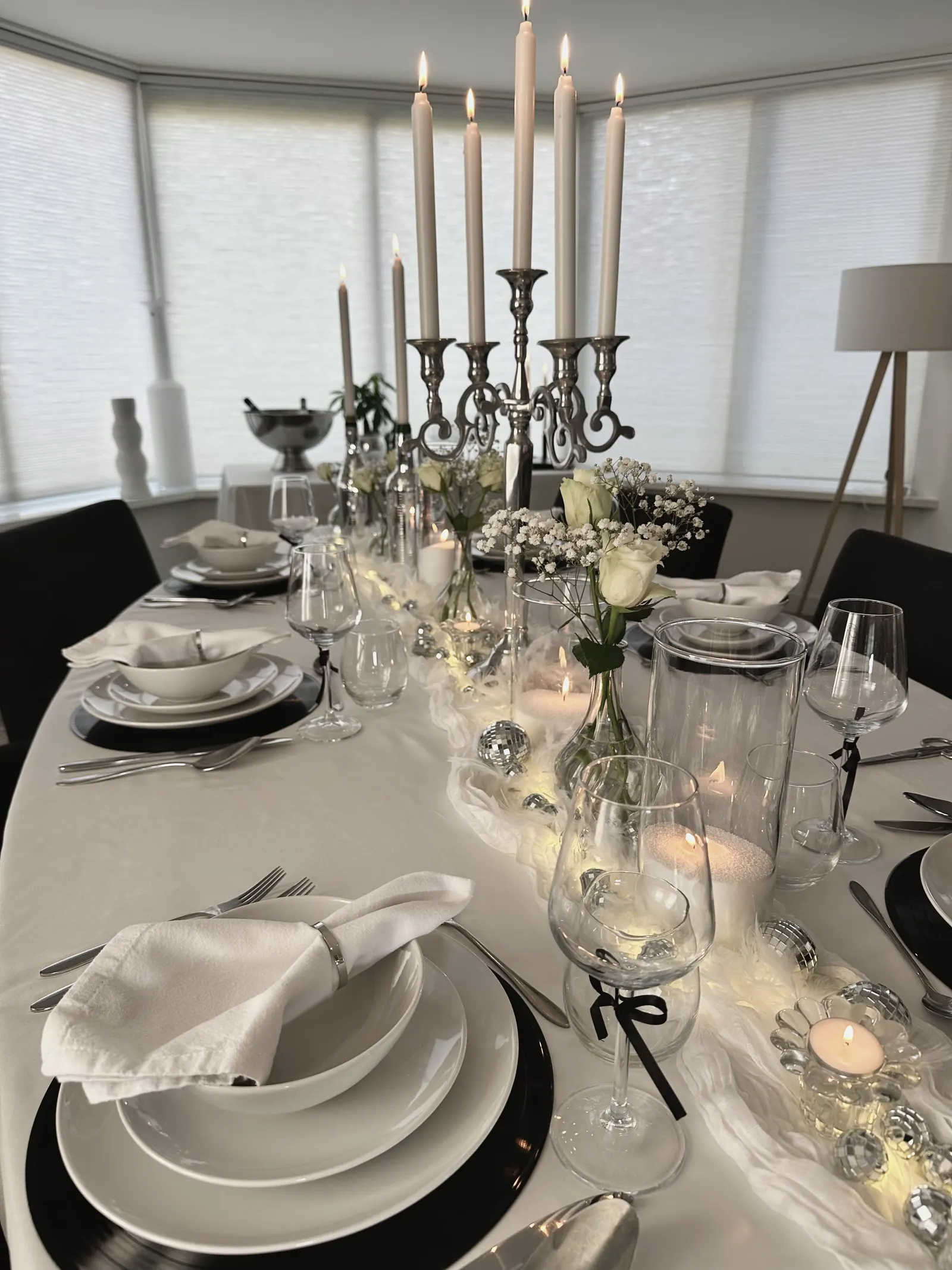 Disco Fever tafel met zwarte onderborden, witte servetten en een hoge kandelaar met witte kaarsen