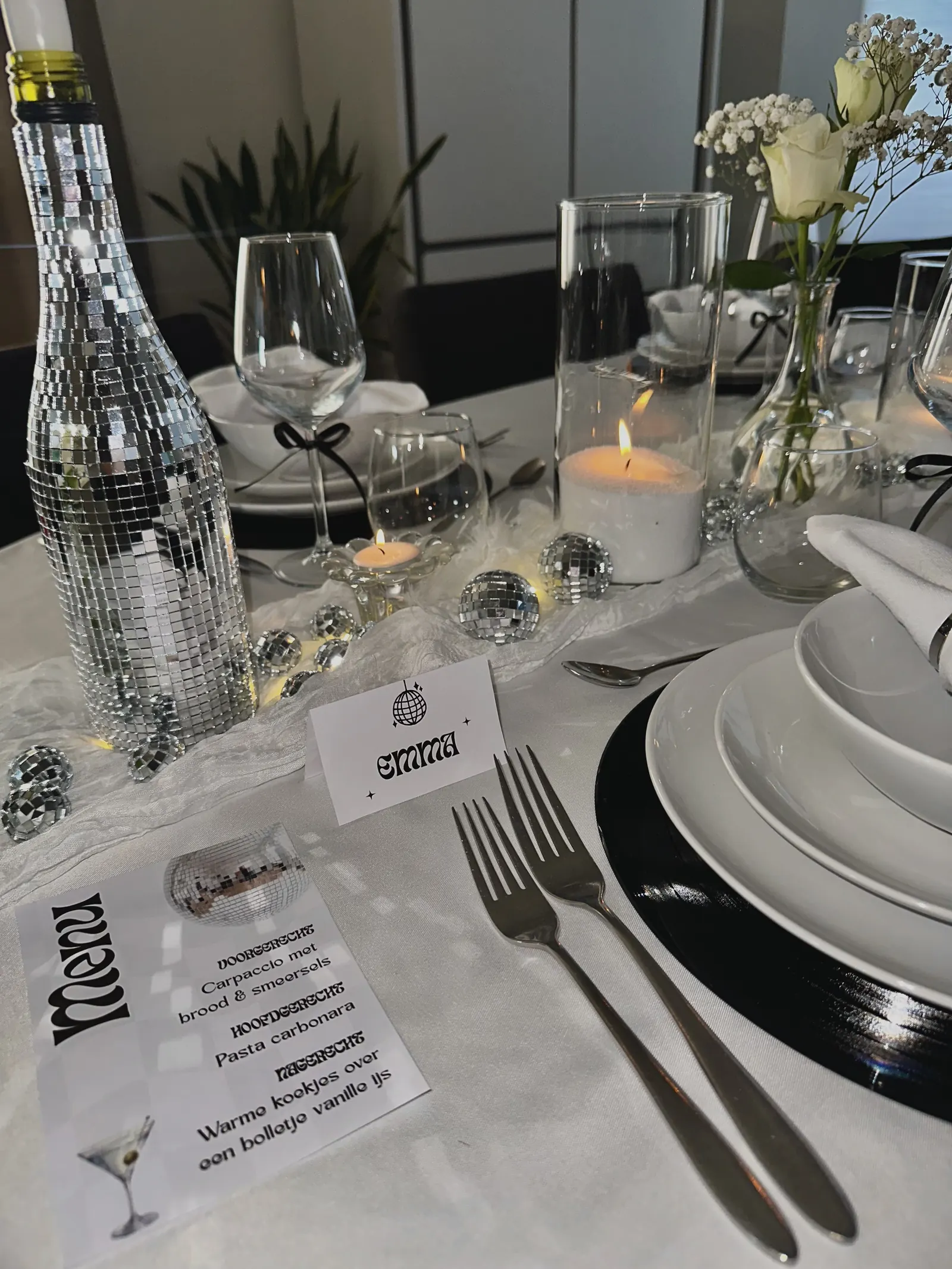 Menukaart en naamkaartje met een discobal naast een spiegelende fles op de Disco Fever tafel
