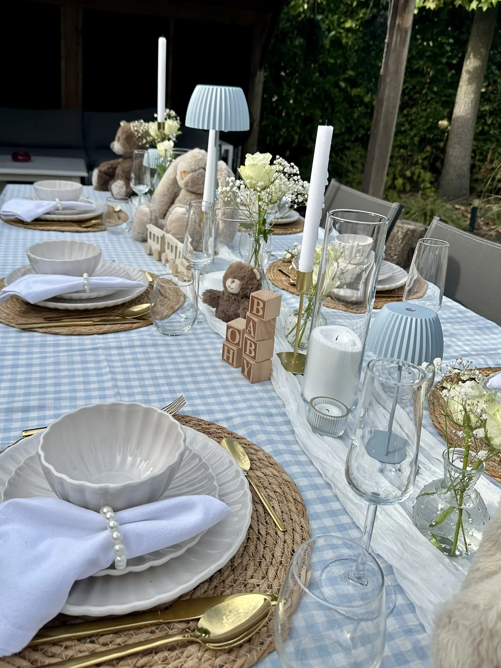 Babyshowertafel met witte schaaltjes, een lichtblauw tafellampje en houten blokken