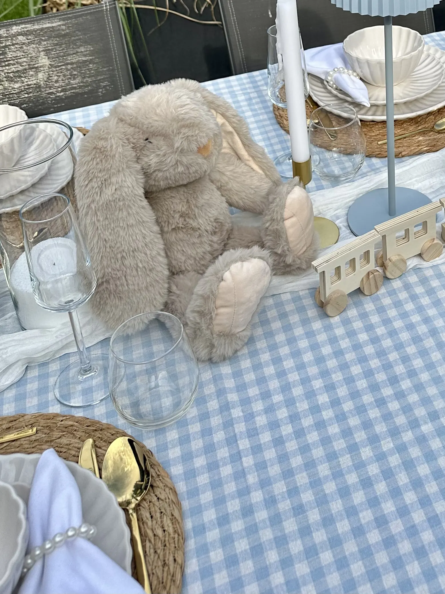 Knuffelkonijn en een houten treintje tussen de borden op de Baby Boy tafel