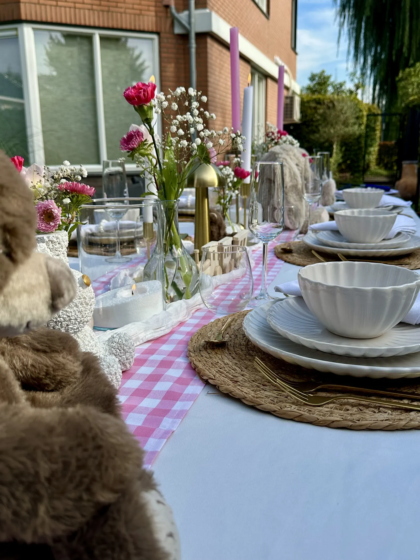 Zijaanzicht van de Baby Girl tafel met witte schaaltjes, roze rozen en een knuffel