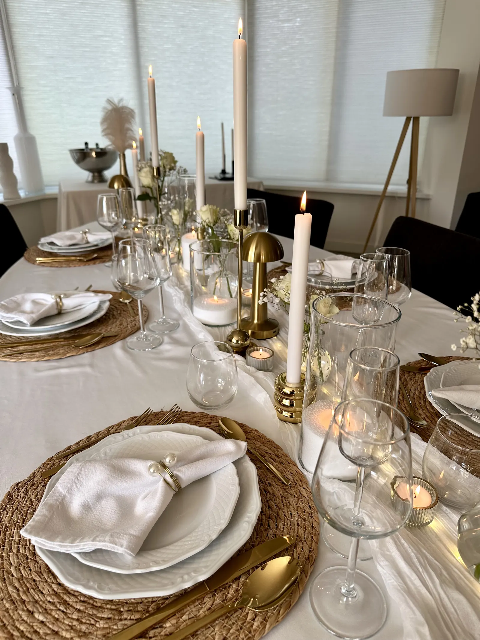 Gedekte plaatsen met gouden tafellampjes, witte kaarsen en kristallen glazen
